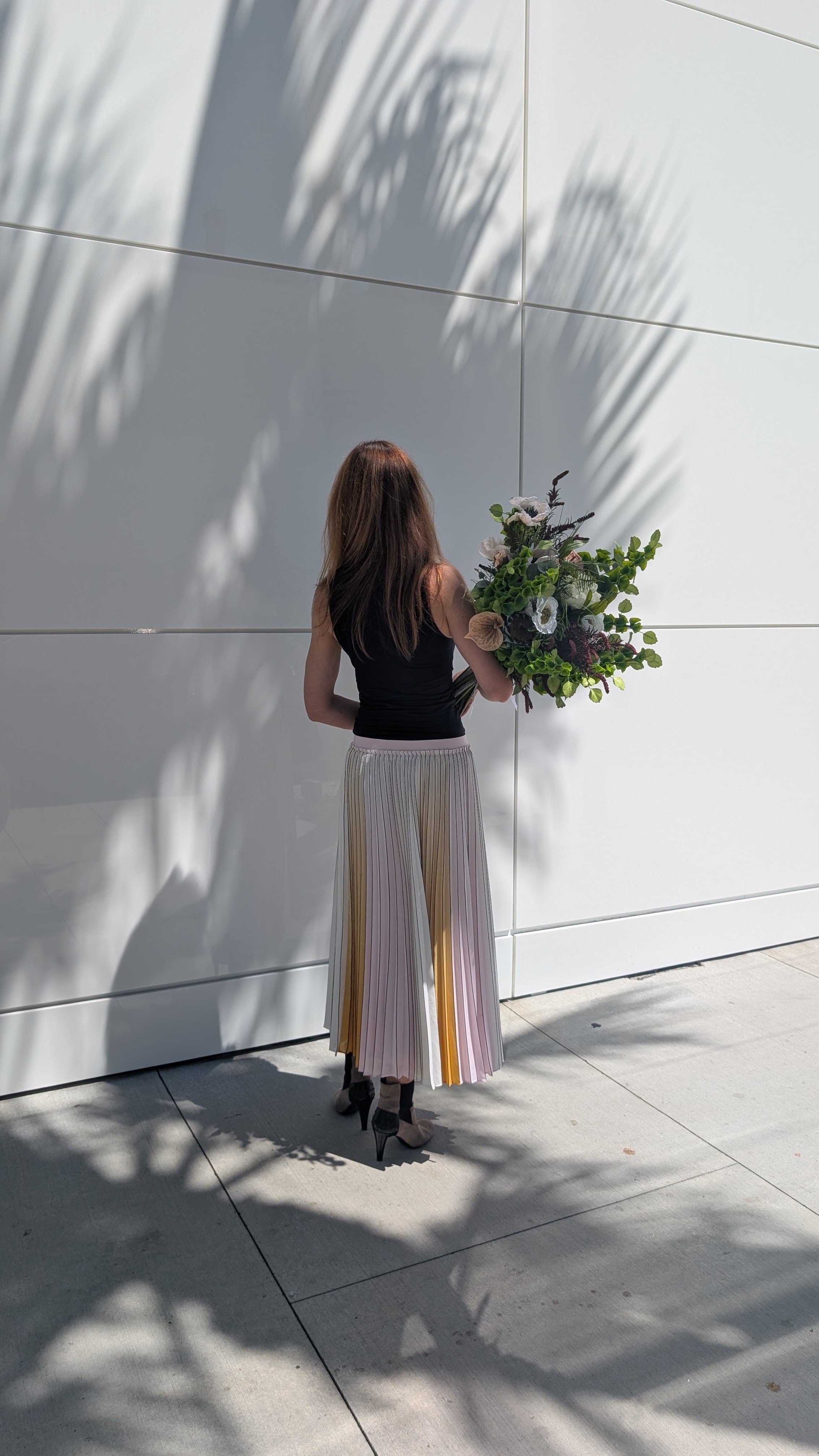 Portrait of the Atelier Bloem founder from behind, holding the green bouquet