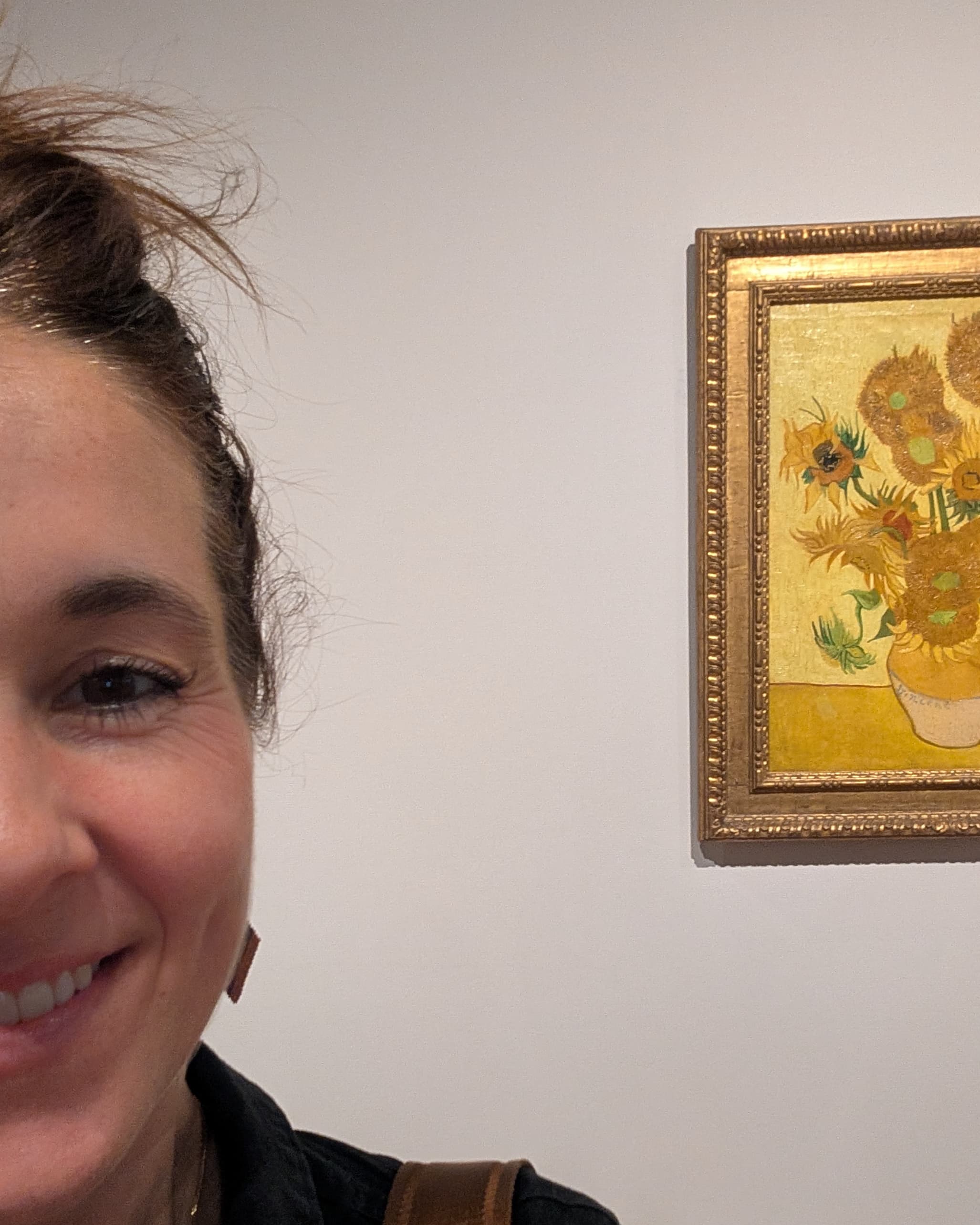 Monique van Schaik standing before Van Gogh's Sunflowers at the Van Gogh Museum